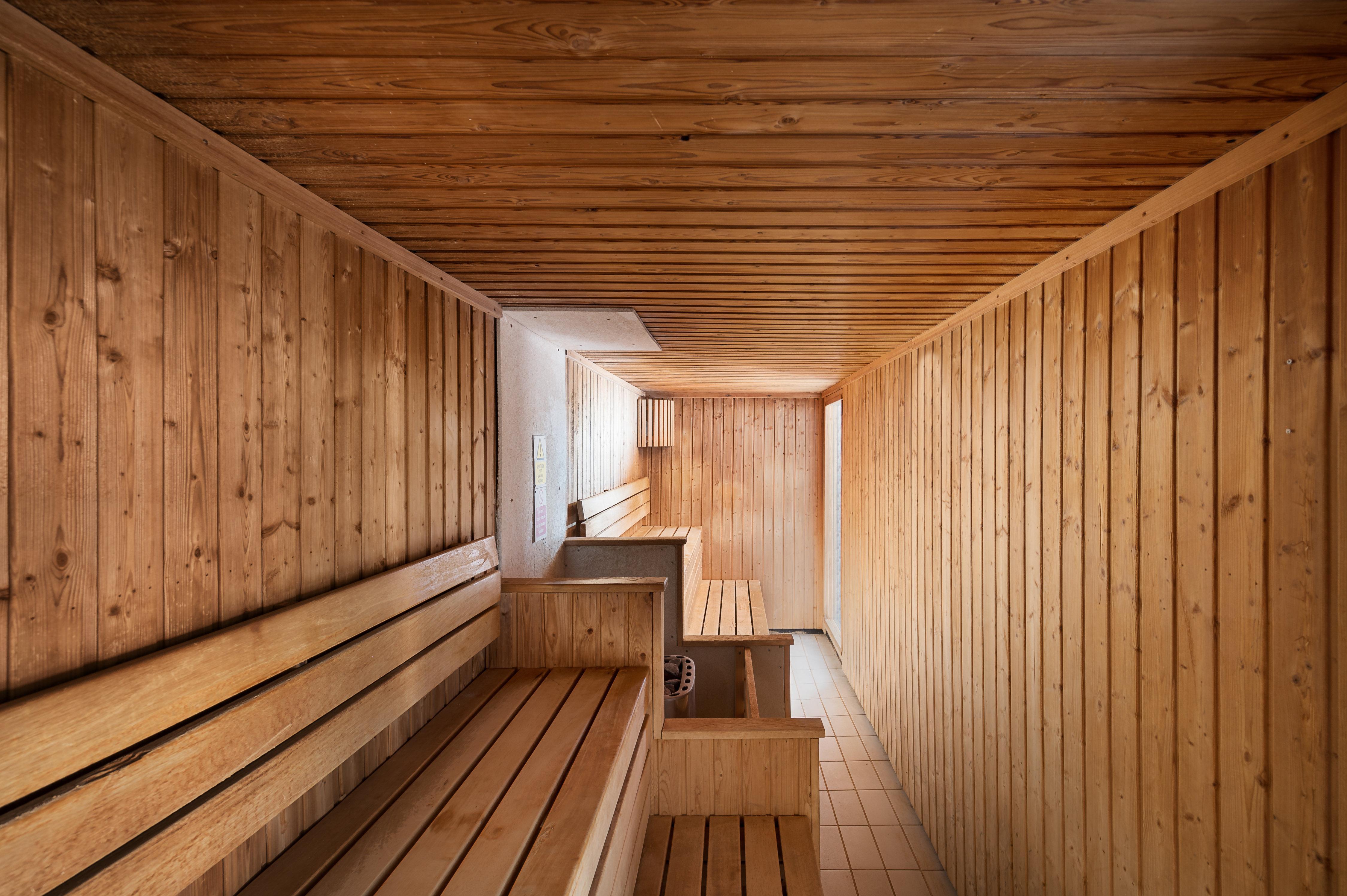 Voco St. David'S Cardiff By Ihg Hotel Buitenkant foto The photo depicts the interior of a sauna. It features wooden walls, ceiling, and benches, creating a warm and inviting atmosphere. The benches are arranged on either side of the room, with a space in the middle. The flooring is tiled, and there is a